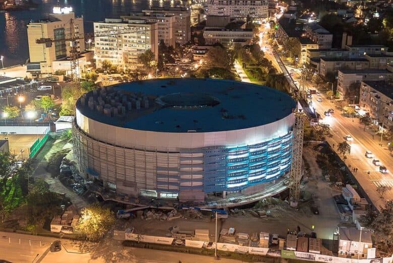 Clădire modernă în construcție în orașul Tulcea, iluminată pe timp de noapte.