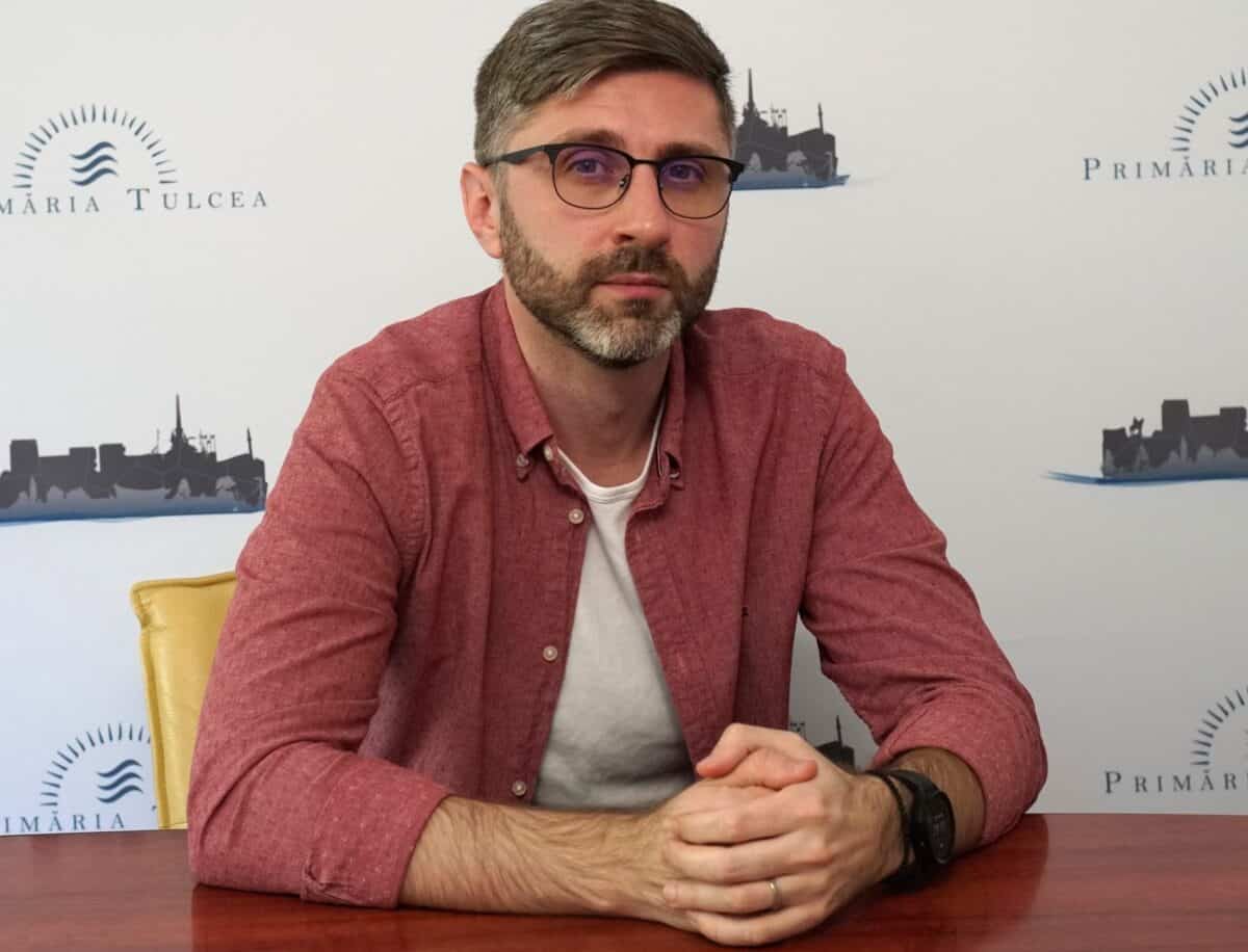 Peisaj cu bărbat în ședință la masa de întâlnire, cadrul oficial al orașului Tulcea, România, pentru promovarea turismului local.