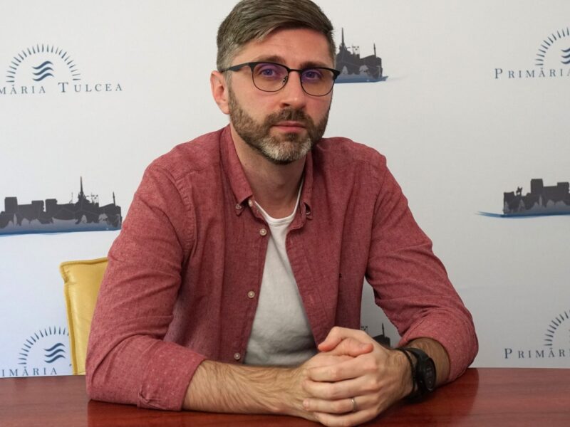 Peisaj cu bărbat în ședință la masa de întâlnire, cadrul oficial al orașului Tulcea, România, pentru promovarea turismului local.