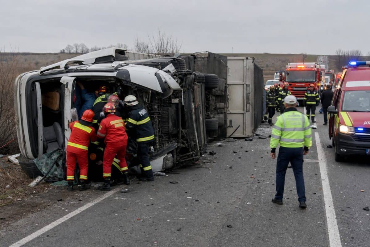 Camion răsturnat pe șosea, cu echipe de intervenție la locul accidentului