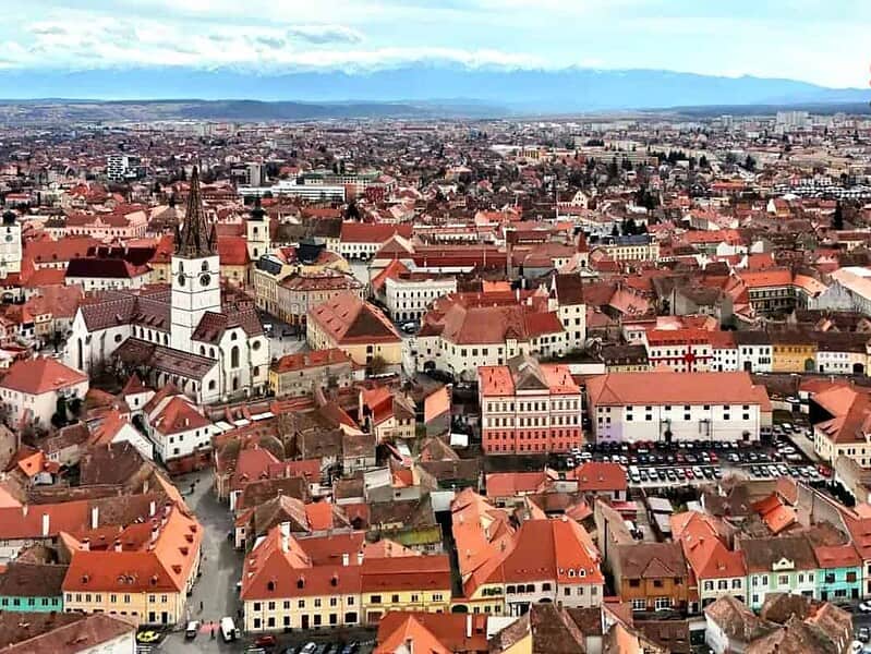 Vedere aeriană din dronă a centrului istoric din Sibiu, cu logo Storia