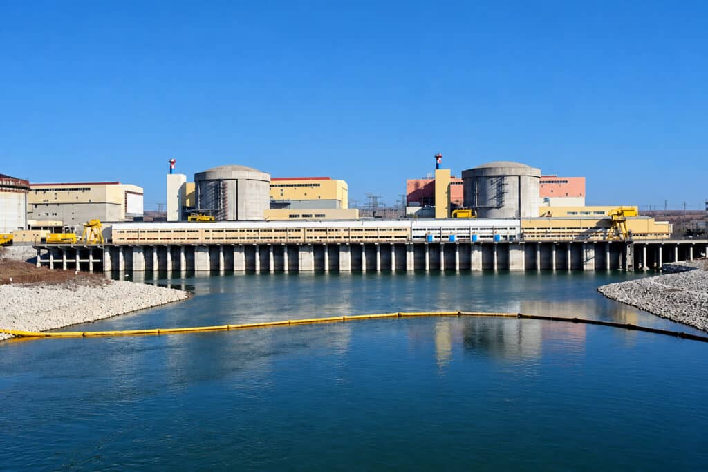 Centrala nucleară de la Cernavodă și canalul cu apă din fața clădirilor, într-o zi senină